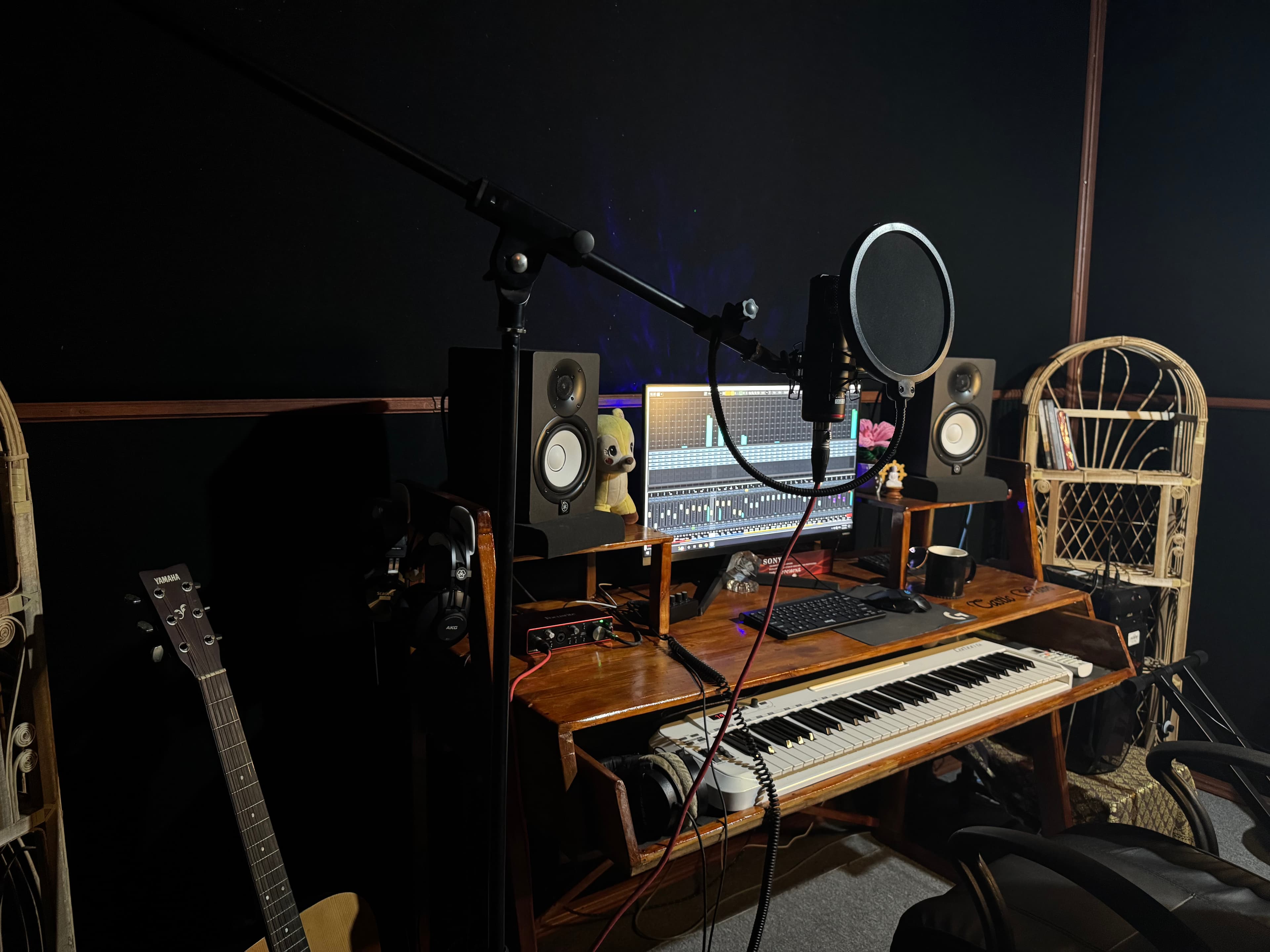 Microphone, pop filter, desk, speakers, and keyboard inside the Tastic Wavs recording space.
